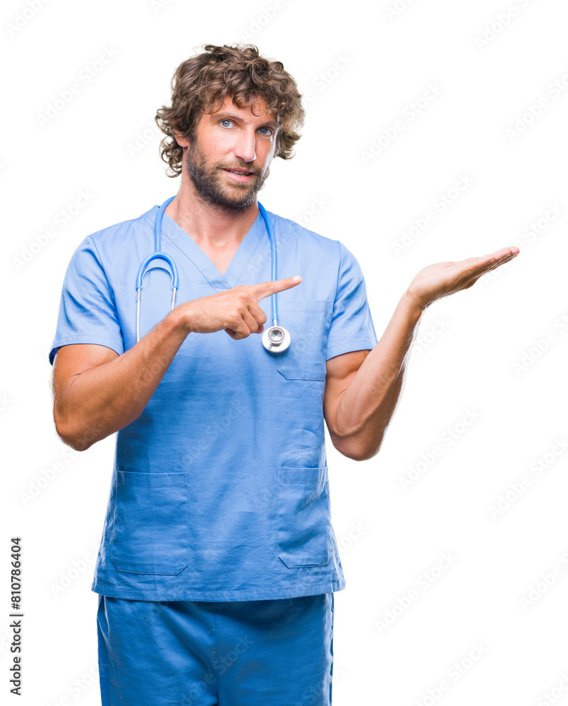 Handsome hispanic surgeon doctor man over isolated background amazed and smiling to the camera while presenting with hand and pointing with finger. Handsome hispanic surgeon doctor man over isolated background amazed and smiling to the camera while presenting with hand and pointing with finger.