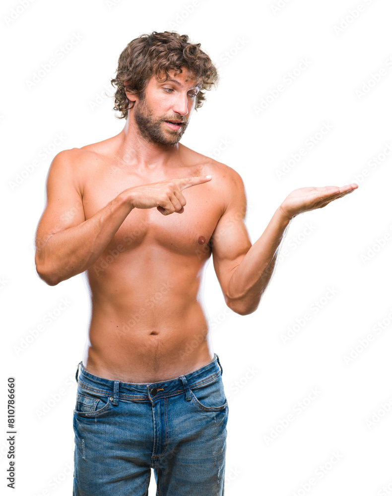 Handsome hispanic model man sexy and shirtless over isolated background amazed and smiling to the camera while presenting with hand and pointing with finger. Handsome hispanic model man sexy and shirtless over isolated background amazed and smiling to the camera while presenting with hand and pointing with finger.