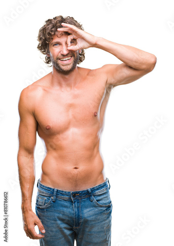Handsome hispanic model man sexy and shirtless over isolated background doing ok gesture with hand smiling, eye looking through fingers with happy face.