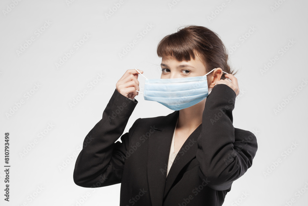 Young businesswoman adjusting medical face mask in a neutral background Young businesswoman adjusting medical face mask in a neutral background