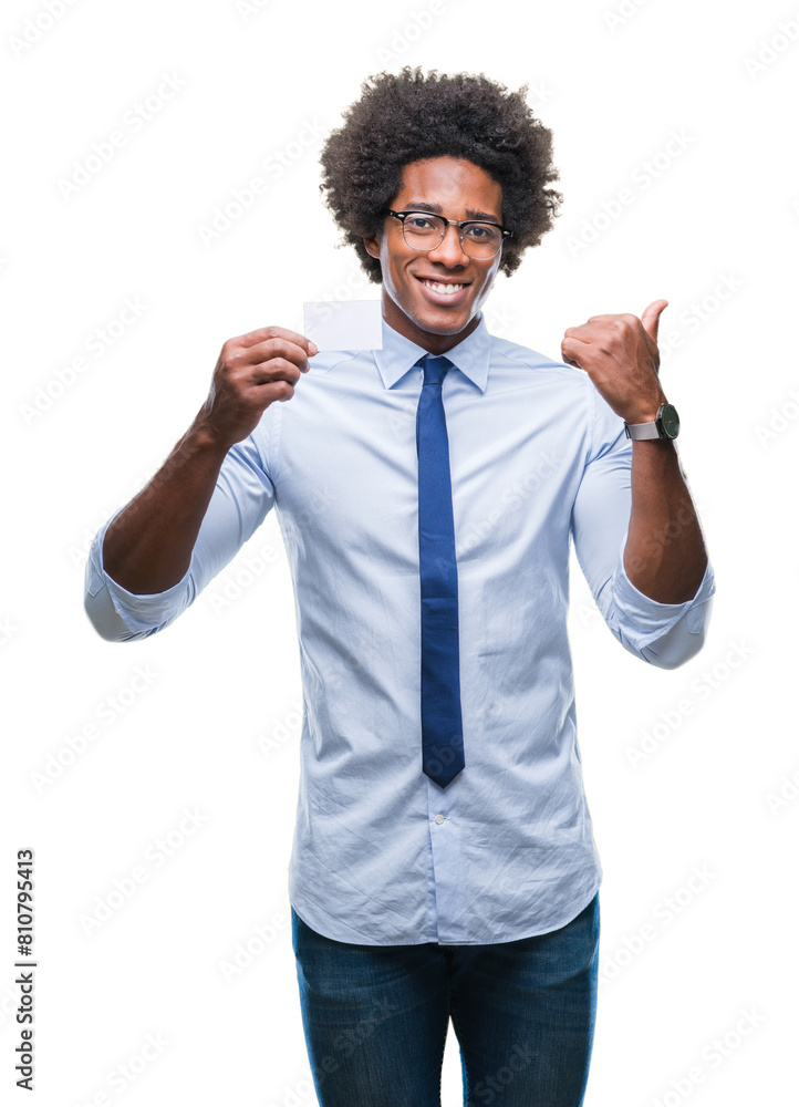 Afro american man holding visit card over isolated background pointing and showing with thumb up to the side with happy face smiling Afro american man holding visit card over isolated background pointing and showing with thumb up to the side with happy face smiling