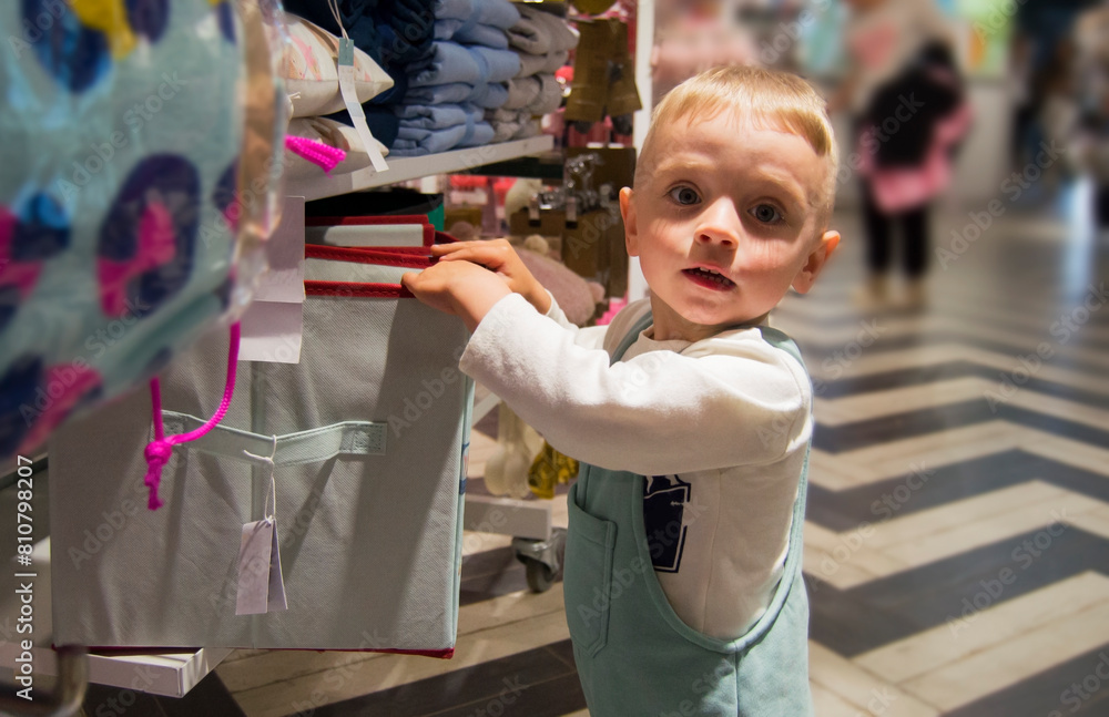 Obraz premium Portrait of cute smiling boy dressed in white T-shirt and mint overalls while spending leisure time in shopping mall at weekend.