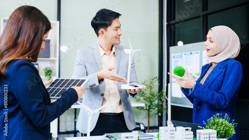 Trio of businesspeople  including a middle-aged Asian man and woman  strategize at their desk  prioritizing sustainability renewable energy adoption  waste reduction  and eco-friendly practices.