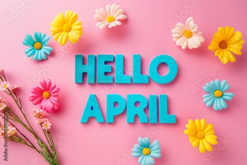 The text Hello April is surrounded by colorful artificial flowers on a pink background © Glittering Humanity