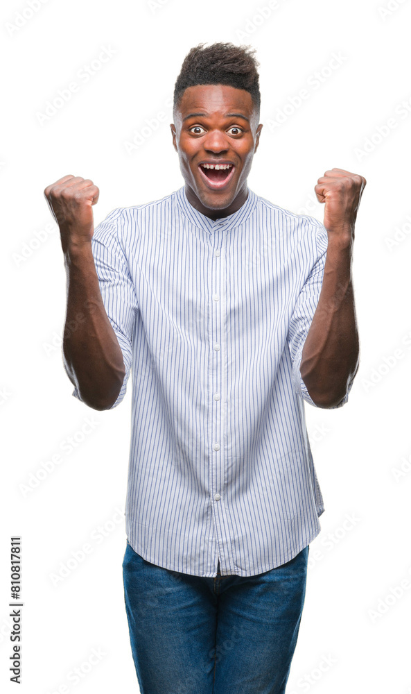 Fototapeta premium Young african american man over isolated background celebrating surprised and amazed for success with arms raised and open eyes. Winner concept.