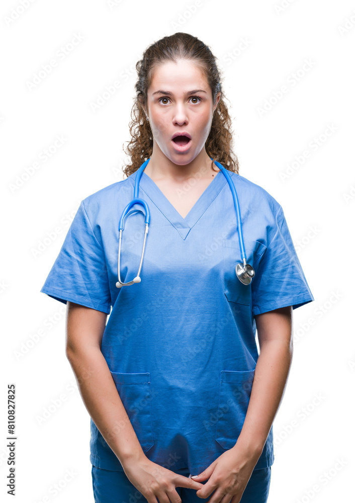 Young brunette doctor girl wearing nurse or surgeon uniform over isolated background afraid and shocked with surprise expression, fear and excited face. Young brunette doctor girl wearing nurse or surgeon uniform over isolated background afraid and shocked with surprise expression, fear and excited face.