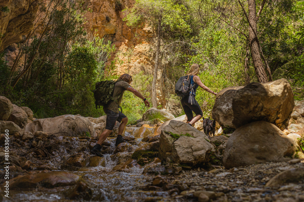 couple walking up a river during a hike in nature.jpg couple walking up a river during a hike in nature.jpg