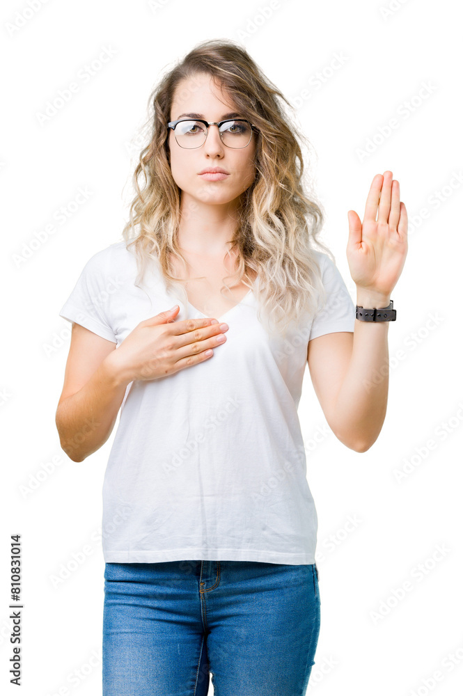 Obraz premium Beautiful young blonde woman wearing glasses over isolated background Swearing with hand on chest and open palm, making a loyalty promise oath