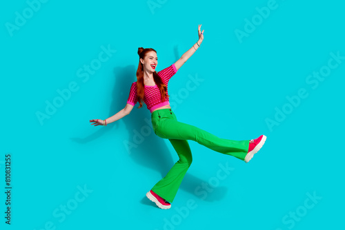 Full length photo of positive carefree lady dressed pink knitted shirt walking emtpy space isolated blue color background
