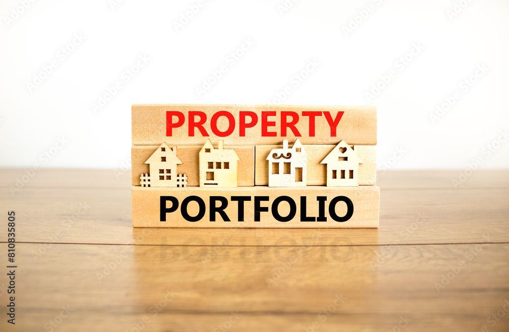 Property portfolio symbol. Concept words Property portfolio on beautiful wooden blocks. Wooden model of houses. Beautiful white background. Business Property portfolio concept. Copy space. Property portfolio symbol. Concept words Property portfolio on beautiful wooden blocks. Wooden model of houses. Beautiful white background. Business Property portfolio concept. Copy space.