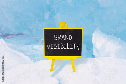 Brand visibility symbol. Concept words Brand visibility on beautiful yellow black blackboard. Beautiful blue ice background. Business branding and brand visibility concept. Copy space.