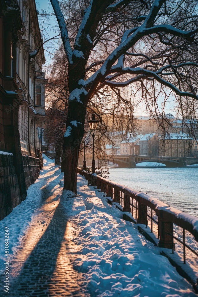 A person walking down a snowy sidewalk next to a river. Suitable for winter-themed designs