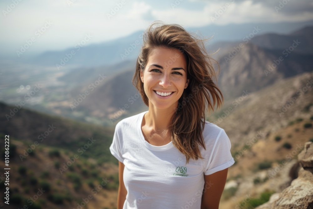 Portrait of a happy woman in her 30s dressed in a casual t-shirt in panoramic mountain vista Portrait of a happy woman in her 30s dressed in a casual t-shirt in panoramic mountain vista
