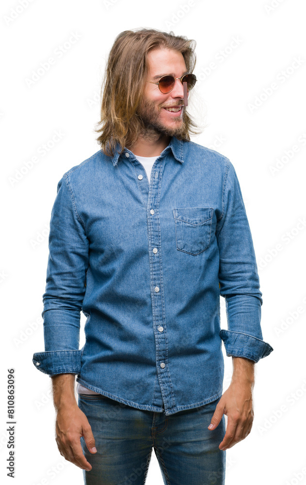 Young handsome man with long hair wearing sunglasses over isolated background looking away to side with smile on face, natural expression. Laughing confident. Young handsome man with long hair wearing sunglasses over isolated background looking away to side with smile on face, natural expression. Laughing confident.