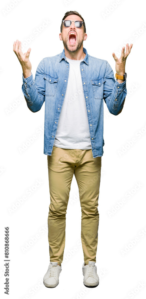Φωτογραφία Handsome man wearing fashion sunglasses celebrating mad and crazy for success with arms raised and closed eyes screaming excited