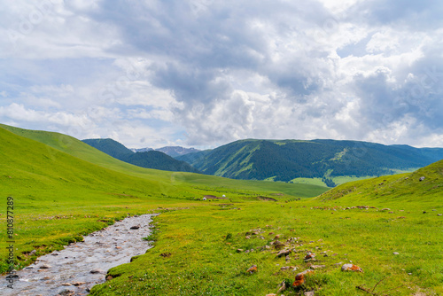 Beautiful nature of Kazakhstan on the Assy plateau in summer. Mountain river, green hills and white yurts