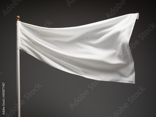 A white flag is on a pole. The flag is very large and is almost touching the ground