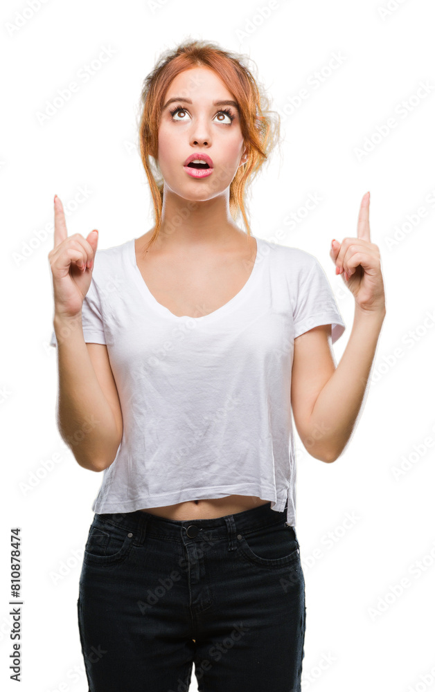 Young beautiful woman over isolated background amazed and surprised looking up and pointing with fingers and raised arms. Young beautiful woman over isolated background amazed and surprised looking up and pointing with fingers and raised arms.