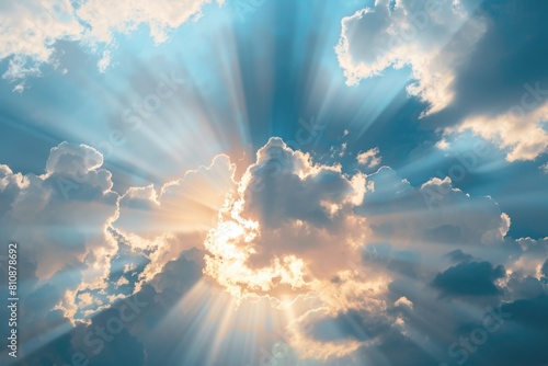 The sun is shining through the clouds, creating a beautiful and serene scene. The light is casting a warm glow on the sky, making it look like a painting. The clouds are scattered throughout the sky