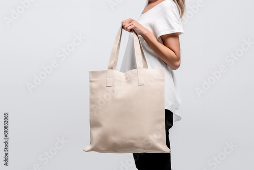 mockup of a girl holding a fabric reusable bag on a white background