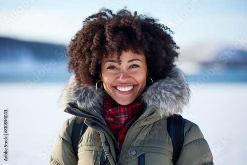 Portrait of a happy afro-american woman in her 30s dressed in a polished vest isolated in backdrop of a frozen winter lake