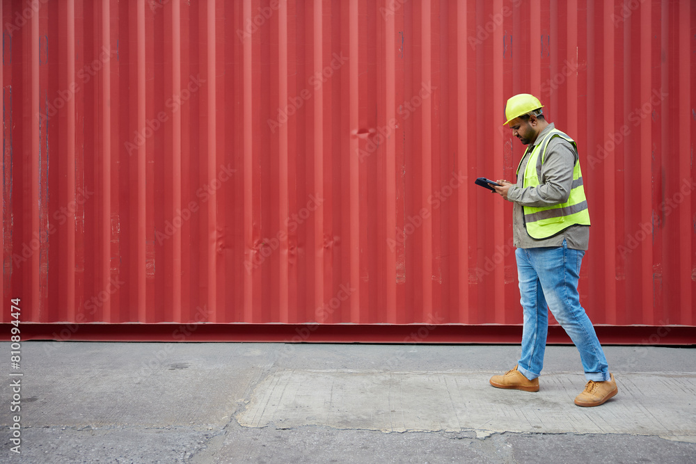 worker or engineer walking forward and working on tablet in containers warehouse storage worker or engineer walking forward and working on tablet in containers warehouse storage