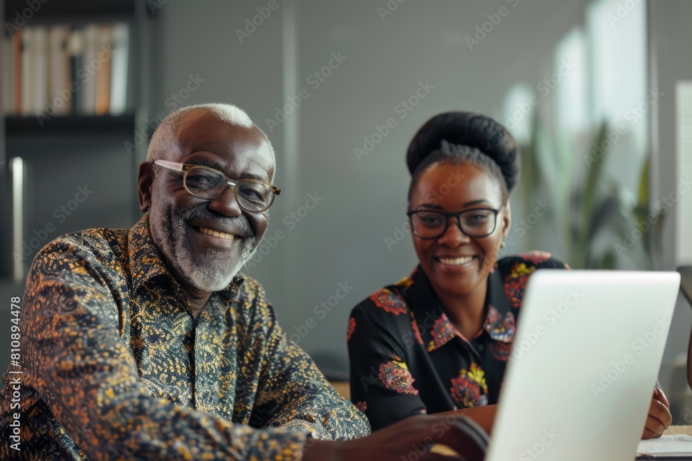 An older man and a younger woman working together on a laptop computer. Fictional Character Created By Generative AI. An older man and a younger woman working together on a laptop computer. Fictional Character Created By Generative AI.