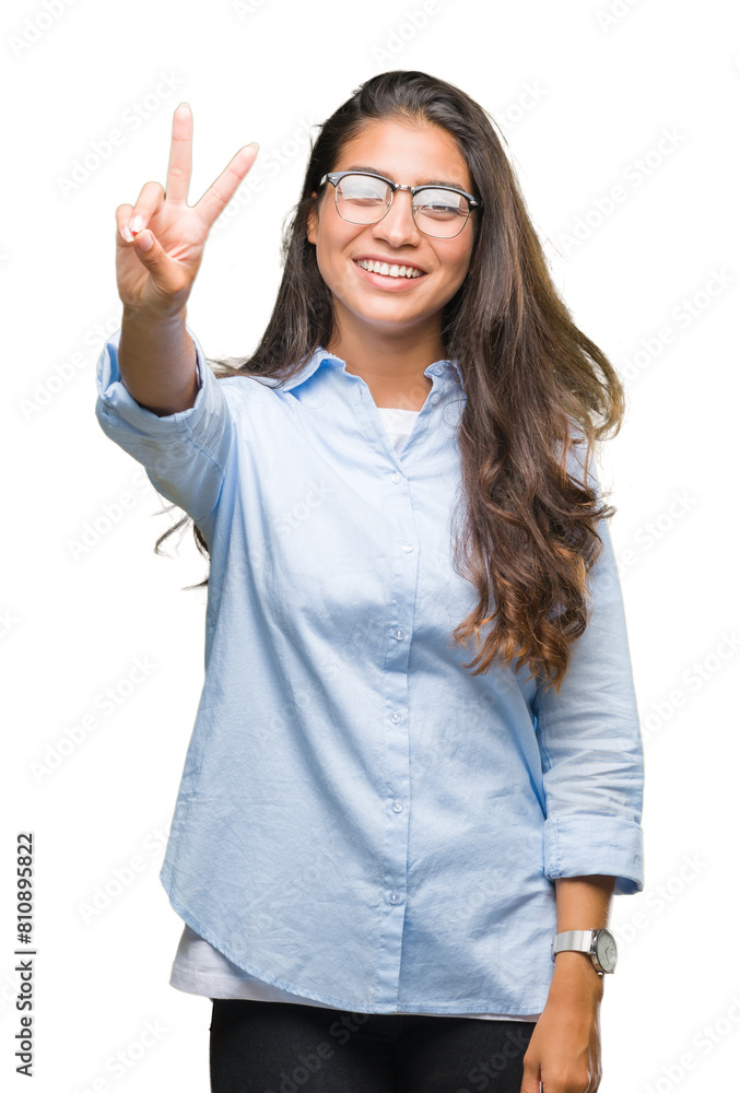 Young beautiful arab woman wearing glasses over isolated background smiling with happy face winking at the camera doing victory sign. Number two. Young beautiful arab woman wearing glasses over isolated background smiling with happy face winking at the camera doing victory sign. Number two.