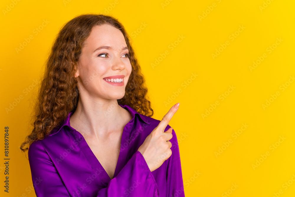 Photo portrait of pretty young girl point look empty space wear trendy violet outfit isolated on yellow color background Photo portrait of pretty young girl point look empty space wear trendy violet outfit isolated on yellow color background