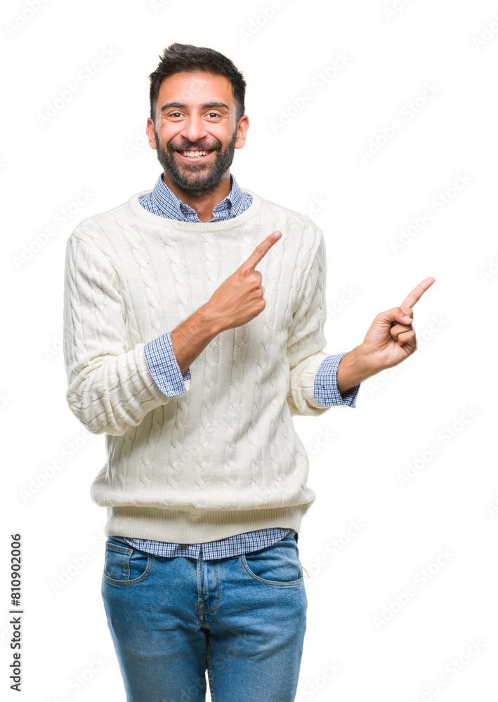 Adult hispanic man wearing winter sweater over isolated background smiling and looking at the camera pointing with two hands and fingers to the side. Adult hispanic man wearing winter sweater over isolated background smiling and looking at the camera pointing with two hands and fingers to the side.
