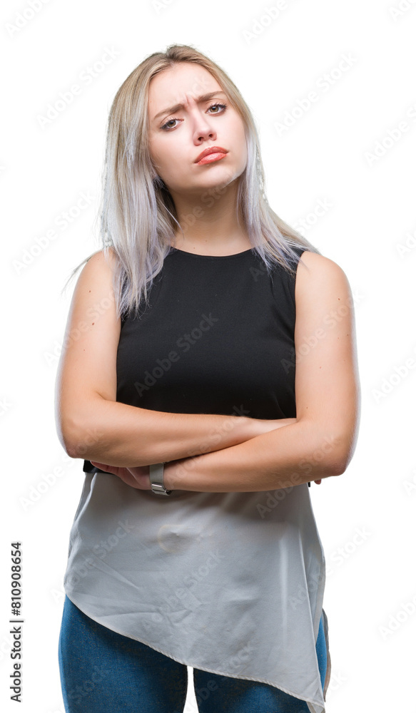 Young blonde woman over isolated background skeptic and nervous, disapproving expression on face with crossed arms. Negative person. Young blonde woman over isolated background skeptic and nervous, disapproving expression on face with crossed arms. Negative person.