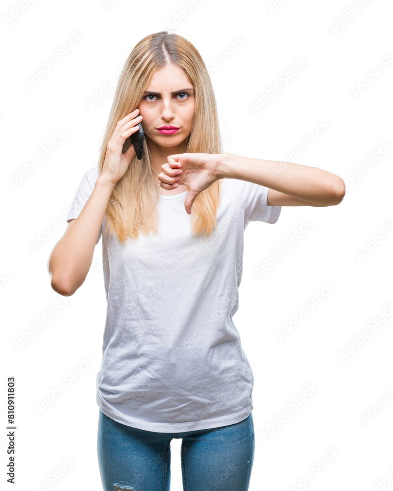 Young beautiful blonde woman talking using smartphone over isolated background with angry face, negative sign showing dislike with thumbs down, rejection concept Young beautiful blonde woman talking using smartphone over isolated background with angry face, negative sign showing dislike with thumbs down, rejection concept