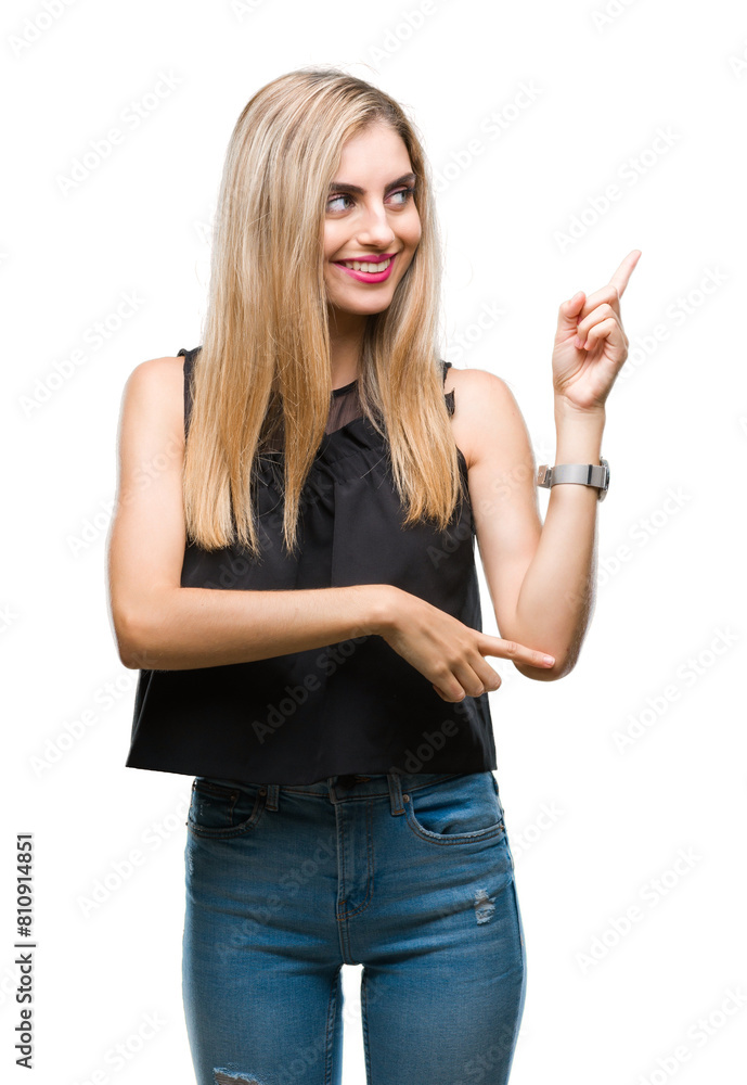 Young beautiful blonde and blue eyes woman over isolated background with a big smile on face, pointing with hand and finger to the side looking at the camera. Young beautiful blonde and blue eyes woman over isolated background with a big smile on face, pointing with hand and finger to the side looking at the camera.