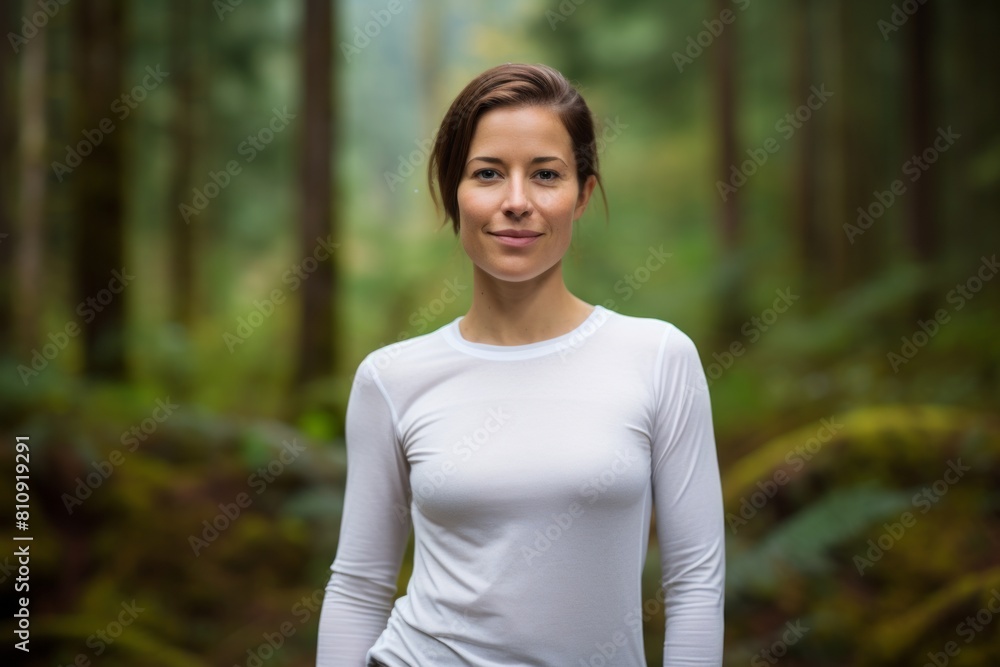 Portrait of a satisfied woman in her 30s sporting a long-sleeved thermal undershirt in front of backdrop of a mystical forest Portrait of a satisfied woman in her 30s sporting a long-sleeved thermal undershirt in front of backdrop of a mystical forest