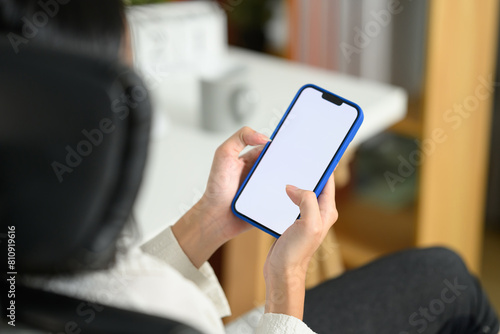 Close up businesswoman holding mobile phone with empty screen sitting at office desk