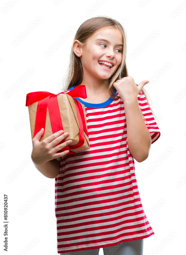 Young beautiful girl giving christmas or valentine gift over isolated background pointing and showing with thumb up to the side with happy face smiling Young beautiful girl giving christmas or valentine gift over isolated background pointing and showing with thumb up to the side with happy face smiling