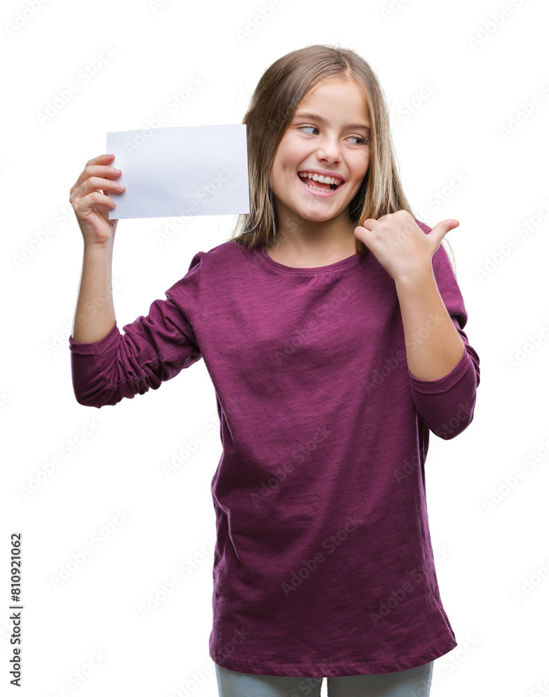 Young beautiful girl holding blank paper card over isolated background pointing and showing with thumb up to the side with happy face smiling Young beautiful girl holding blank paper card over isolated background pointing and showing with thumb up to the side with happy face smiling