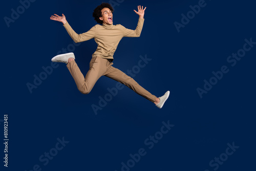 Wallpaper Mural Full size photo of nice young man running excited hurry wear trendy beige outfit isolated on dark blue color background Torontodigital.ca