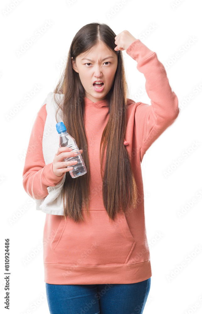 Obraz premium Young Chinese woman over isolated background wearing sport sweathshirt annoyed and frustrated shouting with anger, crazy and yelling with raised hand, anger concept