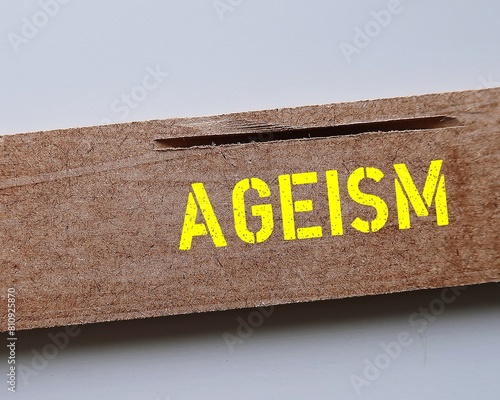 Wood piece with yellow text AGEISM, bias against discrimination or bullying on elderly against their age photo