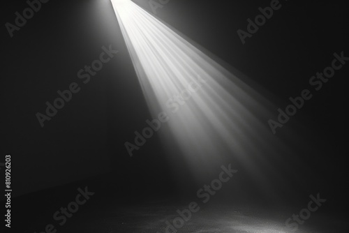 A dark room with a spotlight shining on the floor. The light is bright and creates a dramatic effect