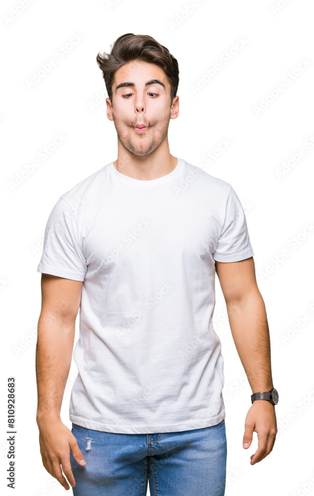 Obraz premium Young handsome man wearing white t-shirt over isolated background making fish face with lips, crazy and comical gesture. Funny expression.