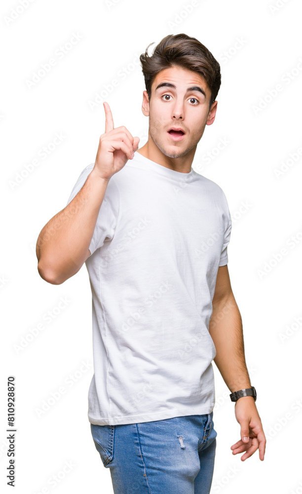 Young handsome man wearing white t-shirt over isolated background pointing finger up with successful idea. Exited and happy. Number one. Young handsome man wearing white t-shirt over isolated background pointing finger up with successful idea. Exited and happy. Number one.
