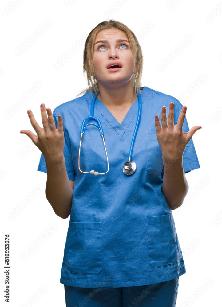 Young caucasian doctor woman wearing surgeon uniform over isolated background crazy and mad shouting and yelling with aggressive expression and arms raised. Frustration concept. Young caucasian doctor woman wearing surgeon uniform over isolated background crazy and mad shouting and yelling with aggressive expression and arms raised. Frustration concept.