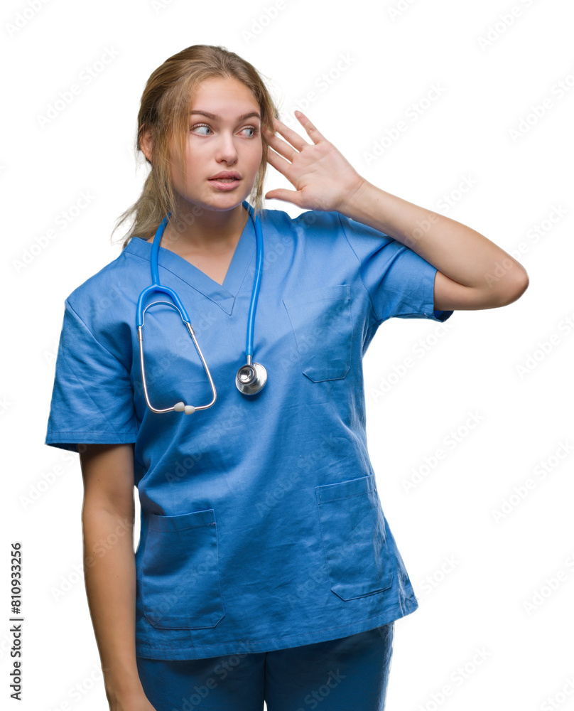 Young caucasian doctor woman wearing surgeon uniform over isolated background smiling with hand over ear listening an hearing to rumor or gossip. Deafness concept. Young caucasian doctor woman wearing surgeon uniform over isolated background smiling with hand over ear listening an hearing to rumor or gossip. Deafness concept.