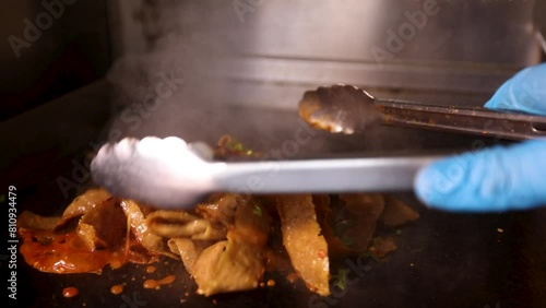 Doner meat being cooked with sauces and seasoning