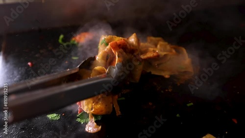 Doner meat with chicken tikka being cooked with sauces and seasoning