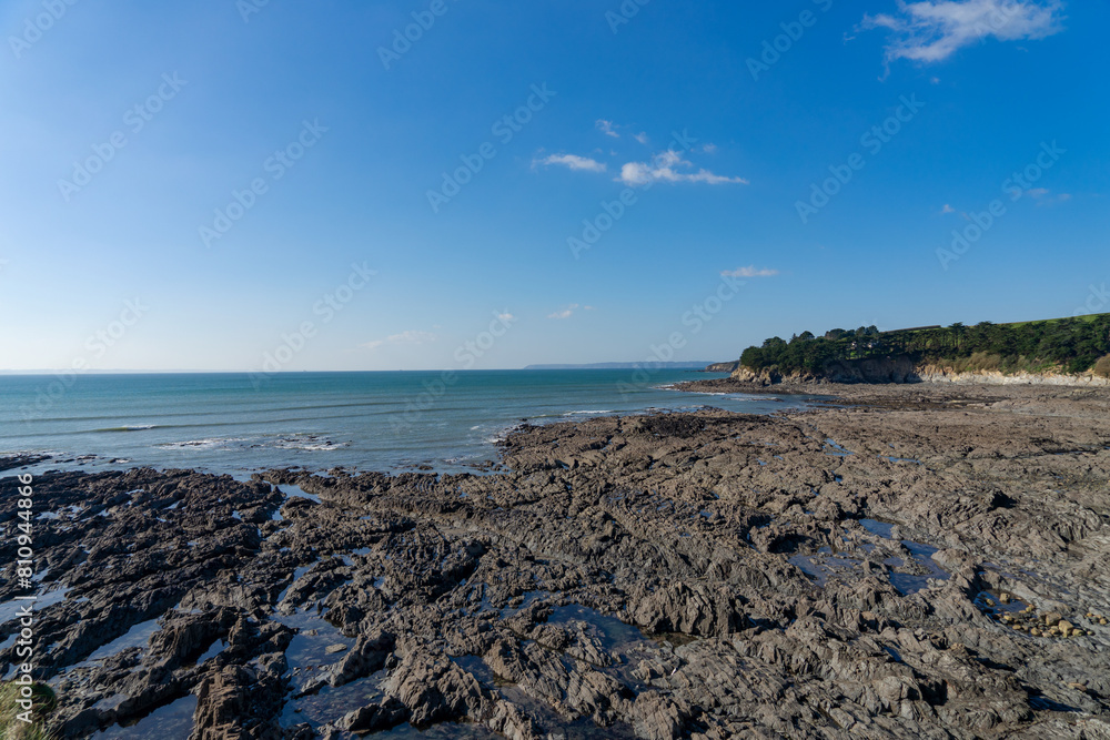 Sous un ciel bleu azur, les fascinants sillons rocheux de la grève de Pors Louz sur la presqu'île de Crozon se dessinent à marée basse. Sous un ciel bleu azur, les fascinants sillons rocheux de la grève de Pors Louz sur la presqu'île de Crozon se dessinent à marée basse.