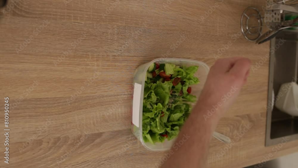 the cook is preparing a vegan salad. a man adds seeds to a salad and mixes it the cook is preparing a vegan salad. a man adds seeds to a salad and mixes it