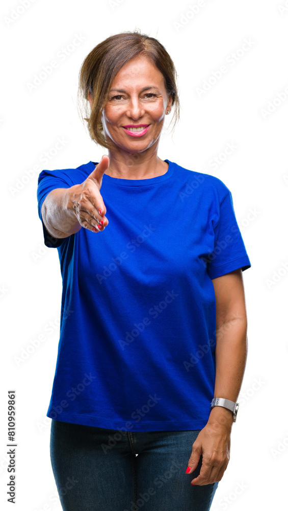 Middle age senior hispanic woman over isolated background smiling friendly offering handshake as greeting and welcoming. Successful business. Middle age senior hispanic woman over isolated background smiling friendly offering handshake as greeting and welcoming. Successful business.